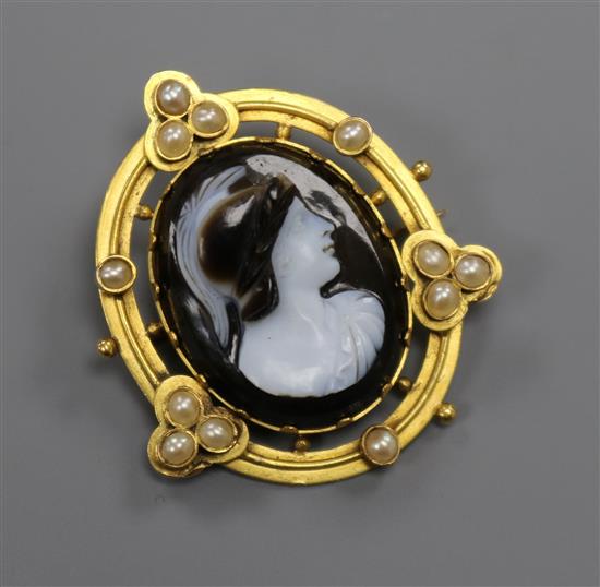 A Victorian oval yellow metal and split pearl framed carved hardstone cameo portrait brooch, depicting a Grecian warrior, 34mm.
